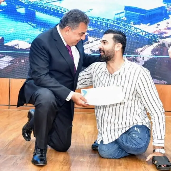 لحظة إنسانية.. محافظ الدقهلية ينحني لعامل لالتقاط صورة خلال احتفالية عيد العمال